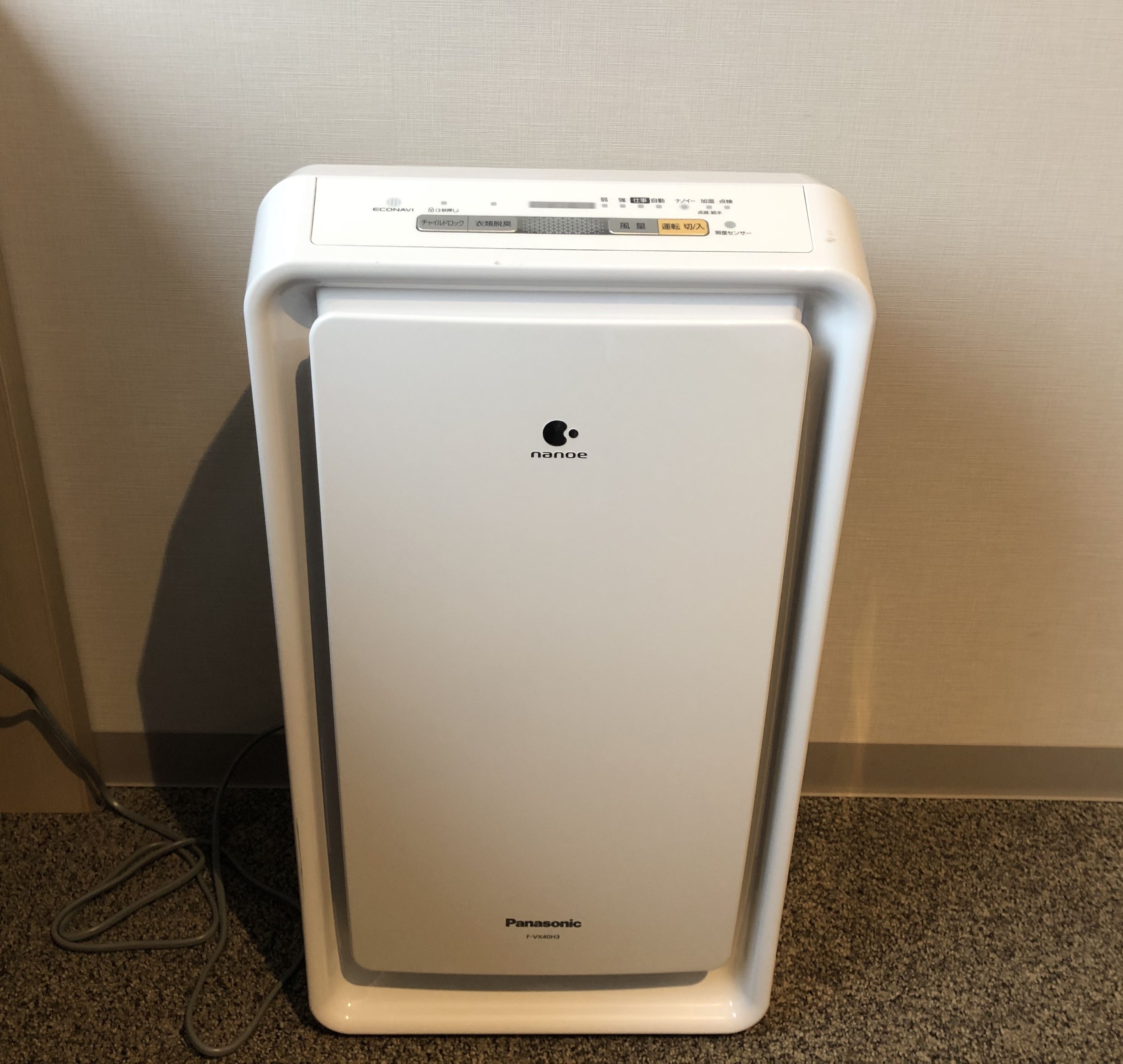 Un refrigerador blanco de Panasonic con pantalla digital y cable de alimentación conectado.