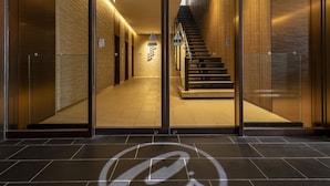 A modern hotel lobby with a glass entrance, a staircase, and a tiled floor. - JR Clement Inn Takamatsu (Takamatsu)