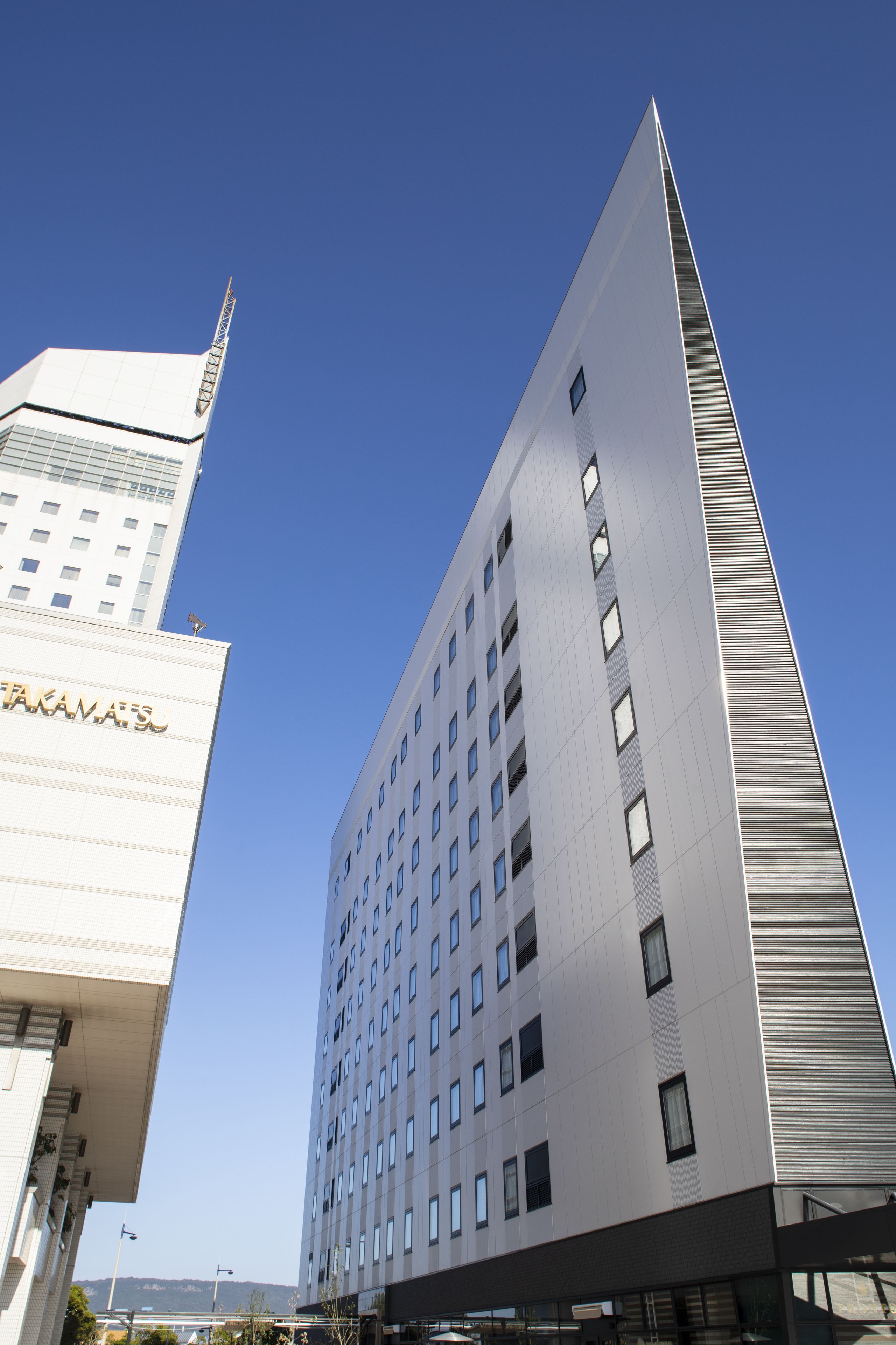 A modern building with a prominent vertical design, featuring a series of windows and a flat roof.