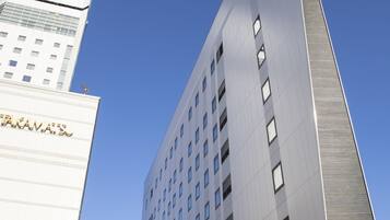 Un edificio moderno con un diseño vertical llamativo, que presenta una serie de ventanas y un techo plano.