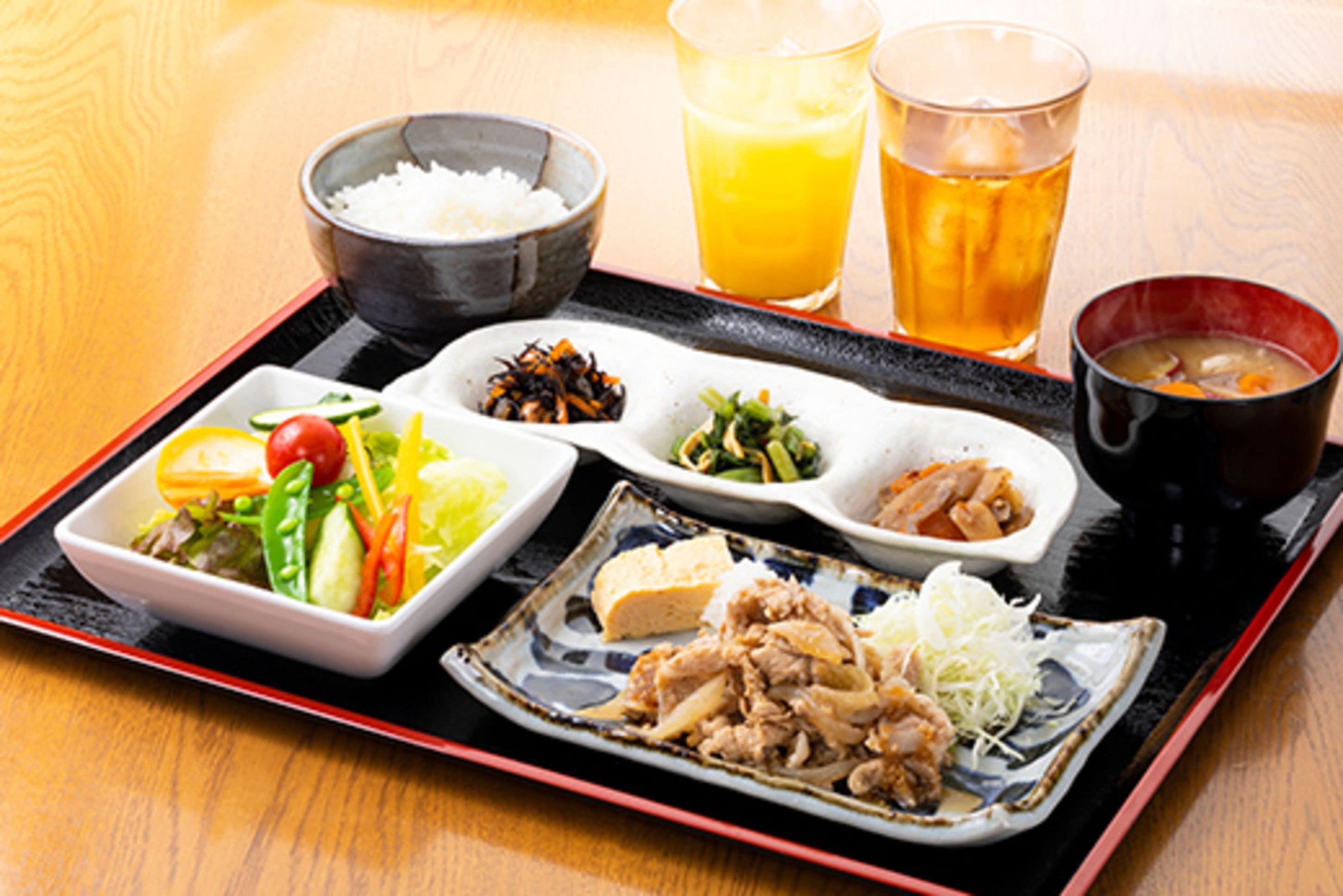 A tray with various dishes including rice, a salad, and a bowl of soup.