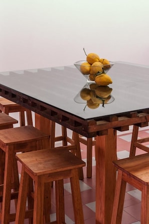 A dining table with chairs, a glass top, and a bowl of fruit. - Baga de Sal Wine Guesthouse (Aveiro)