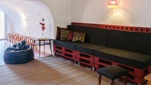 Una sala de estar moderna con un sofá negro, detalles rojos, una mesita y un sillón informal.