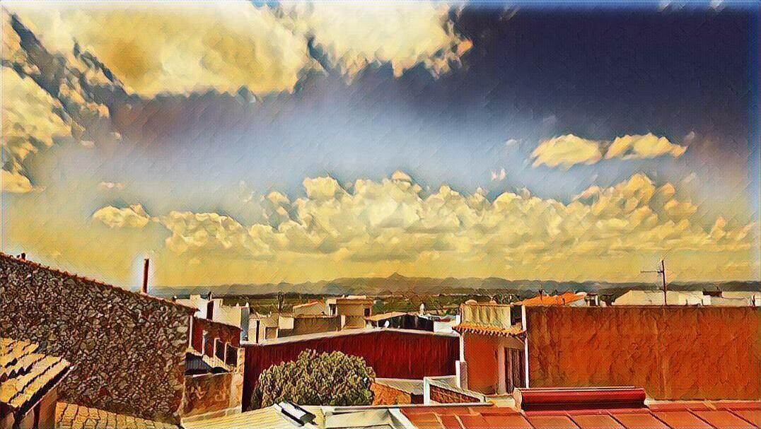 Vista desde la azotea con edificios, cielo despejado y nubes.