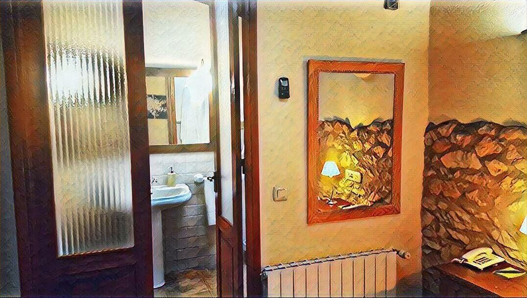 A bathroom with a sink, mirror, and a wall-mounted radiator.