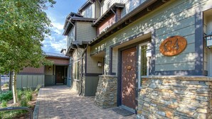 A building with a stone facade, a wooden door, and a number plaque.