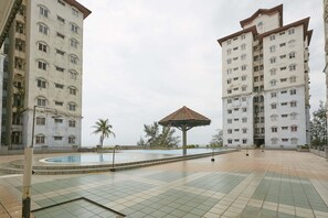 A courtyard with a swimming pool, a gazebo, and two high-rise buildings. - JC Sunshine Bay Resort Port Dickson (Port Dickson)