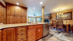 A spacious kitchen with wooden cabinets, granite countertops, and a dishwasher.