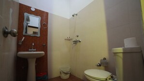 A small bathroom with a sink, toilet, and shower. - Kangs Nirvana Resorts and Spa (Garhshankar)