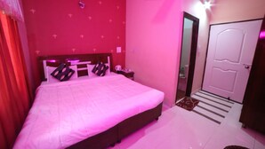 A bedroom with a large bed, a nightstand, a dresser, and a door. - Kangs Nirvana Resorts and Spa (Garhshankar)