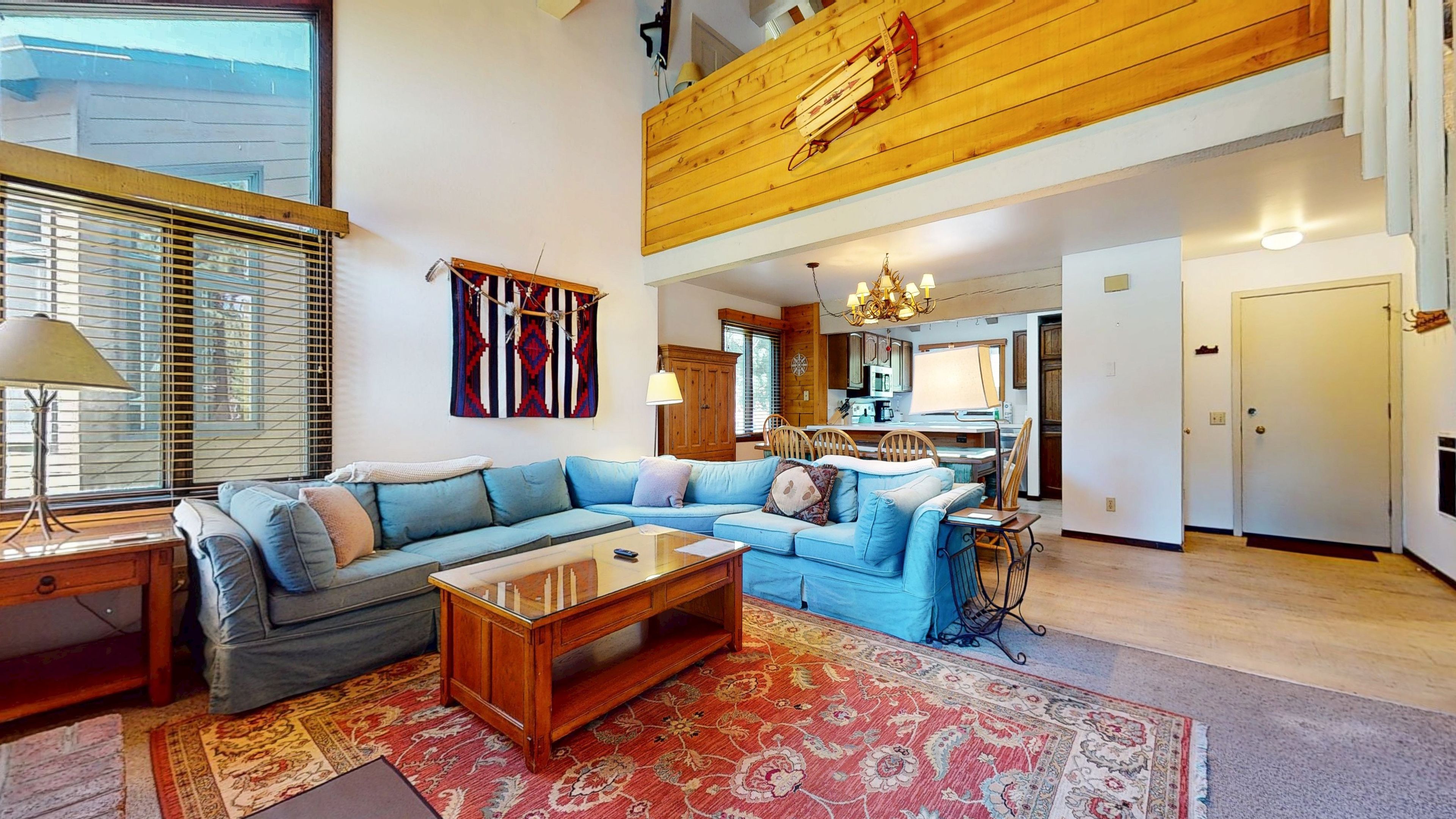 A spacious living area with a sectional sofa, a coffee table, and a patterned rug.