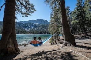 A hammock between two trees overlooking a lake with mountains in the background. - Juniper Crest Townhomes (Mammoth Lakes)