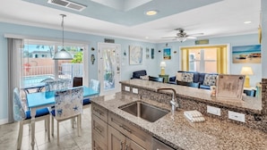 A modern kitchen with granite countertops, a stainless steel sink, and a ceiling fan. - The S 2a 1 Bedroom Villa by RedAwning (Holmes Beach)