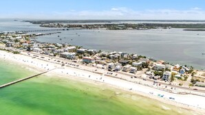 An aerial view of a coastal town with a beach, marina, and residential buildings. - Marmalade Mermaid 3 Bedroom Home by RedAwning (Bradenton Beach)