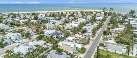 Zona residencial costera con casas, una avenida principal y una playa al fondo.