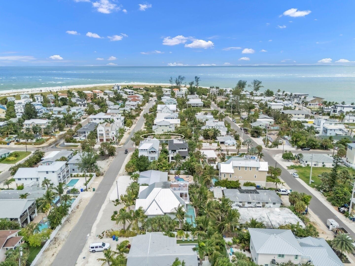 Una zona residencial costera con casas, caminos y una playa.