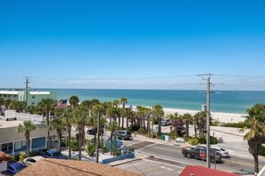 A coastal street with a beach view, palm trees, and parked cars. - Blue Water Escape 3 Bedroom Villa by RedAwning (Bradenton Beach)