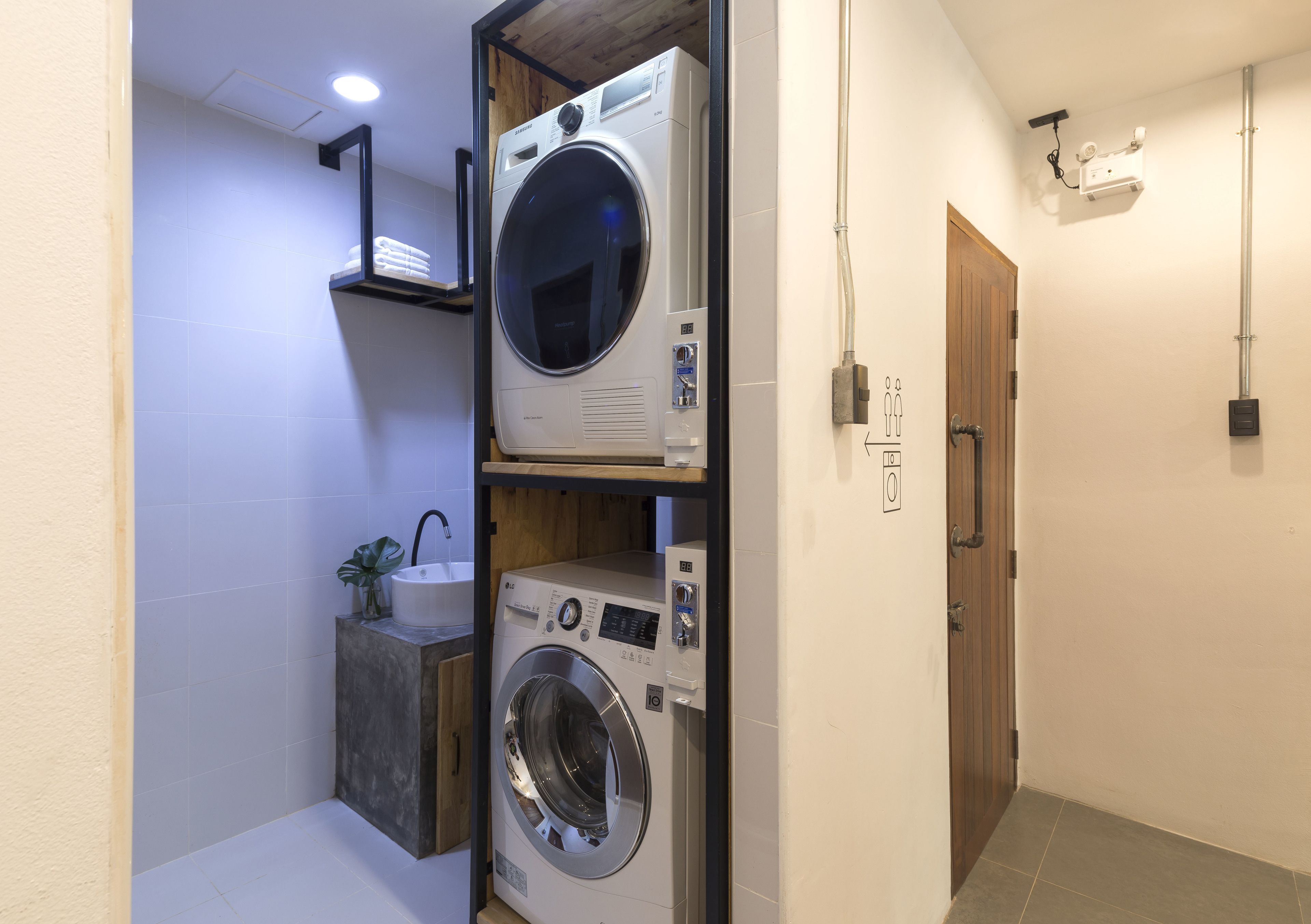 A compact laundry room with a washing machine, dryer, and sink.