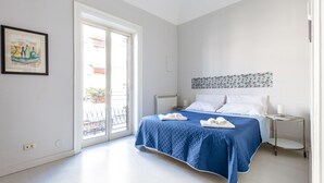 A bedroom with a bed, a bedside table, a radiator, a window, and a door. - Casa Dante with Balcony by Wonderful Italy (Palermo)