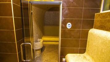 Bathroom features a shower stall with a glass door and a toilet.