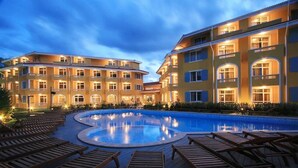 A hotel with a swimming pool surrounded by wooden lounge chairs. - Blue Orange Beach Resort (Sozopol)