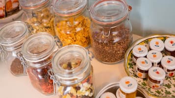 A variety of food items in glass jars and containers, including cereals, nuts, and spreads.