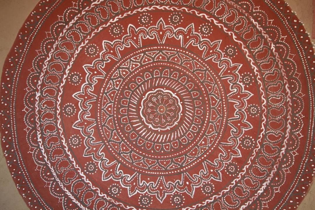 A circular tapestry with a detailed mandala pattern.