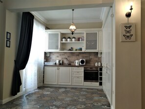 Apartamento design, 1 quarto, no canto | Cozinha privada | Geladeira, fogão, cooktop, cafeteira/chaleira