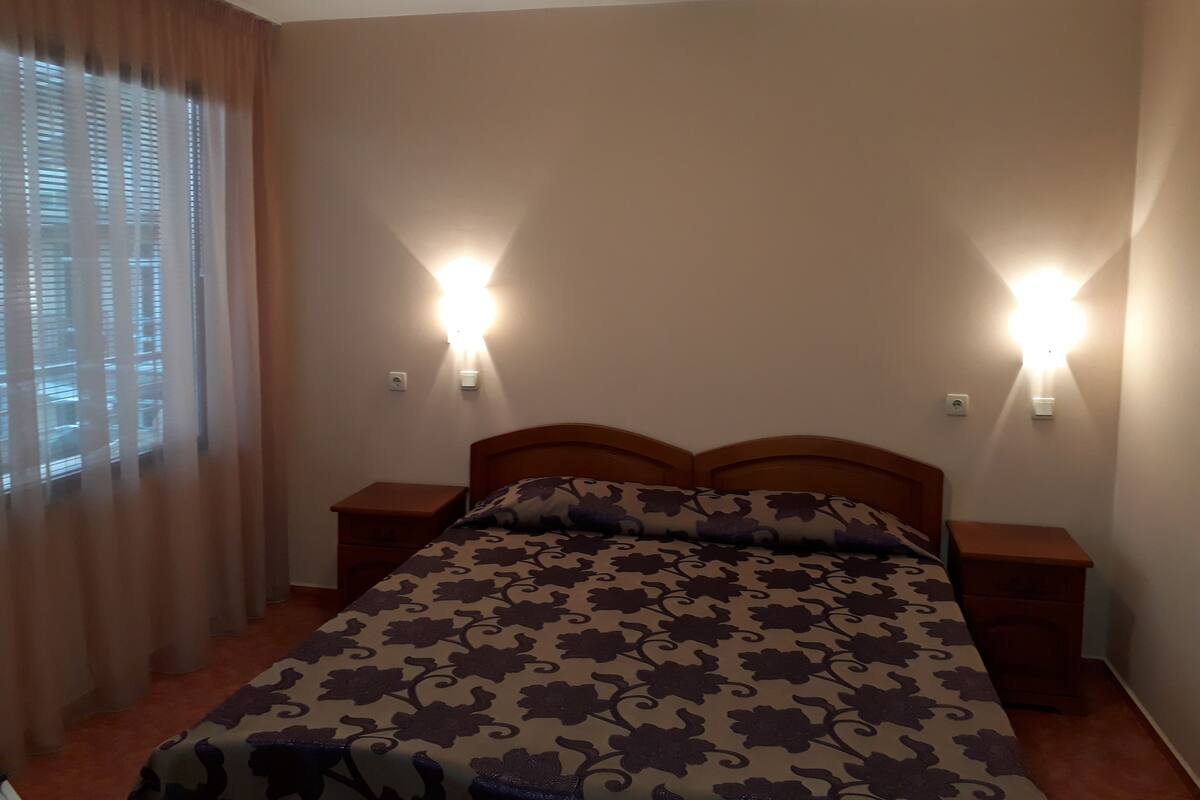 Ein Schlafzimmer mit einem Bett, zwei Nachttischen und zwei Wandleuchten.
