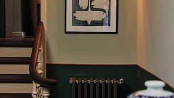 A staircase with a wooden handrail and a radiator below.