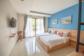 A modern hotel room with two beds, a TV, and a balcony with curtains. - SeeSea Resort (La-ngu)