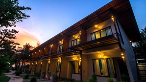 A modern hotel with a covered outdoor area, multiple windows, and a pathway leading to the entrance. - SeeSea Resort (La-ngu)