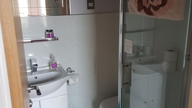 Ducha, artículos de higiene personal gratuitos y toallas