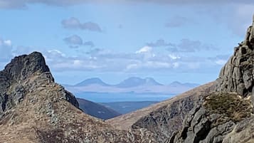A mountainous landscape with rocky terrain and distant mountain ranges.