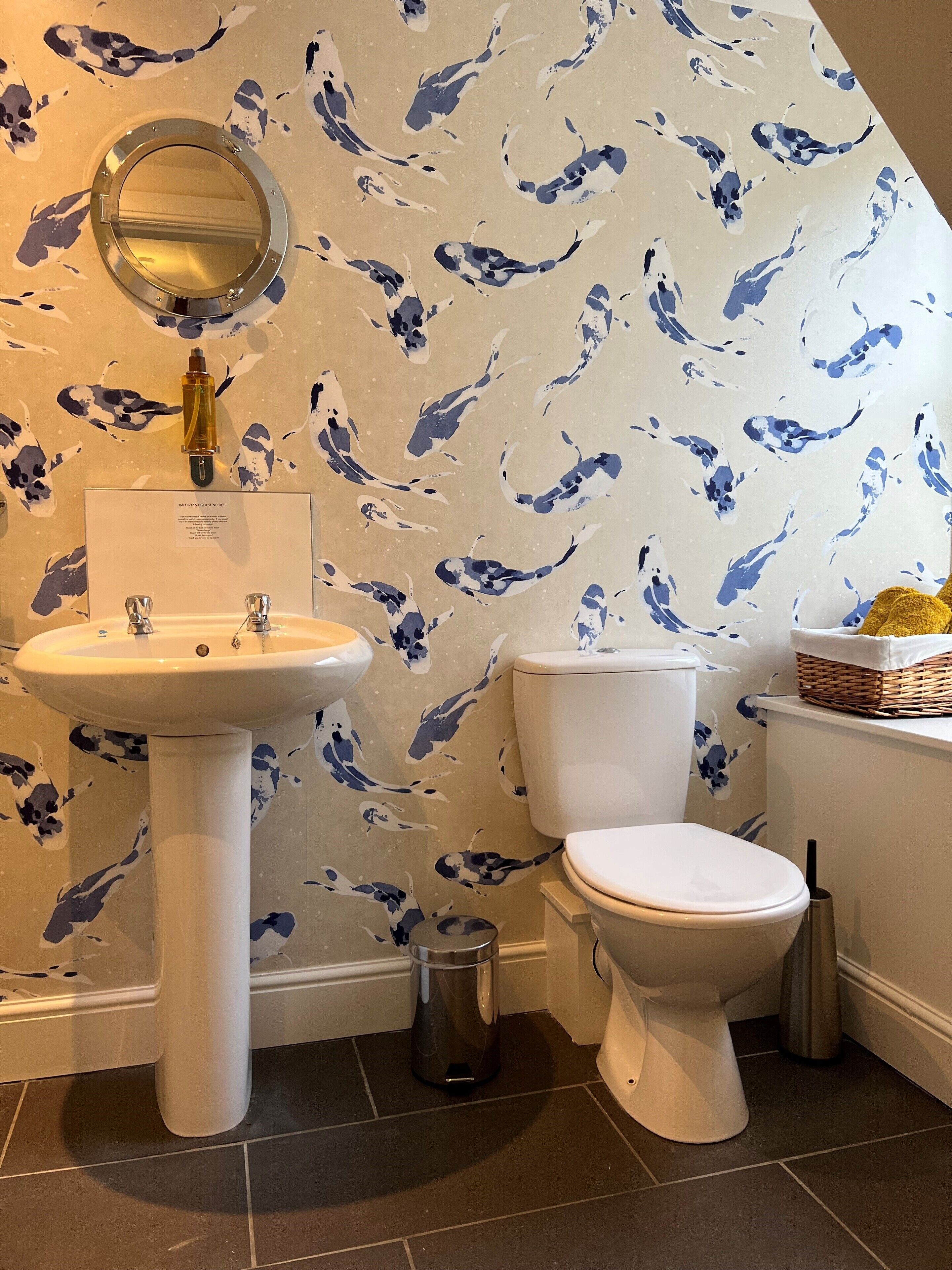 A bathroom with a sink, toilet, and a wall-mounted mirror.