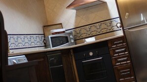 A kitchen with a skylight, a stainless steel refrigerator, a microwave, and a stove. - Apart Rurales Esencias De La Alcarria (Hueva)
