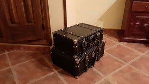 A stack of black suitcases with metal clasps on a tiled floor. - Apart Rurales Esencias De La Alcarria (Hueva)