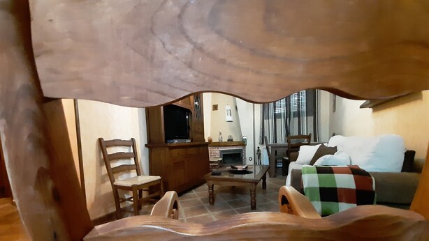 A cozy living room with a fireplace, wooden furniture, and a television. - Apart Rurales Esencias De La Alcarria (Hueva)