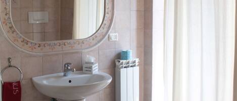 A bathroom with a sink, mirror, and toilet.