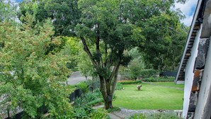 Un jardín con un camino empedrado, una cerca de madera y un banco.