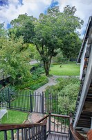 Um jardim com um caminho pavimentado, uma cerca de madeira e um banco.