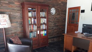 Una sala de estar acogedora con un sillón de cuero, un escritorio de madera, una estantería y una alfombra estampada.