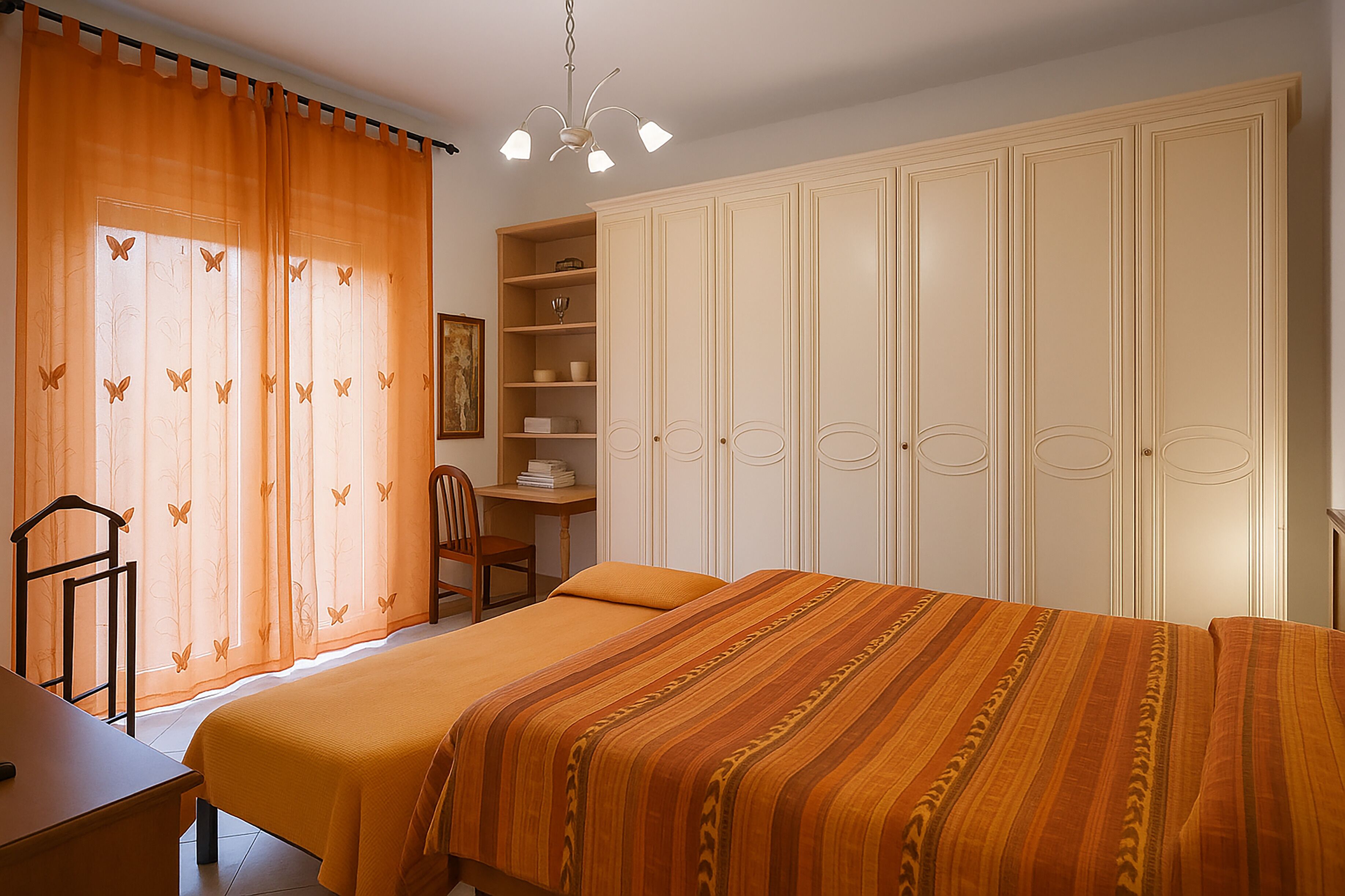 Une chambre avec un grand lit, un bureau et une armoire.