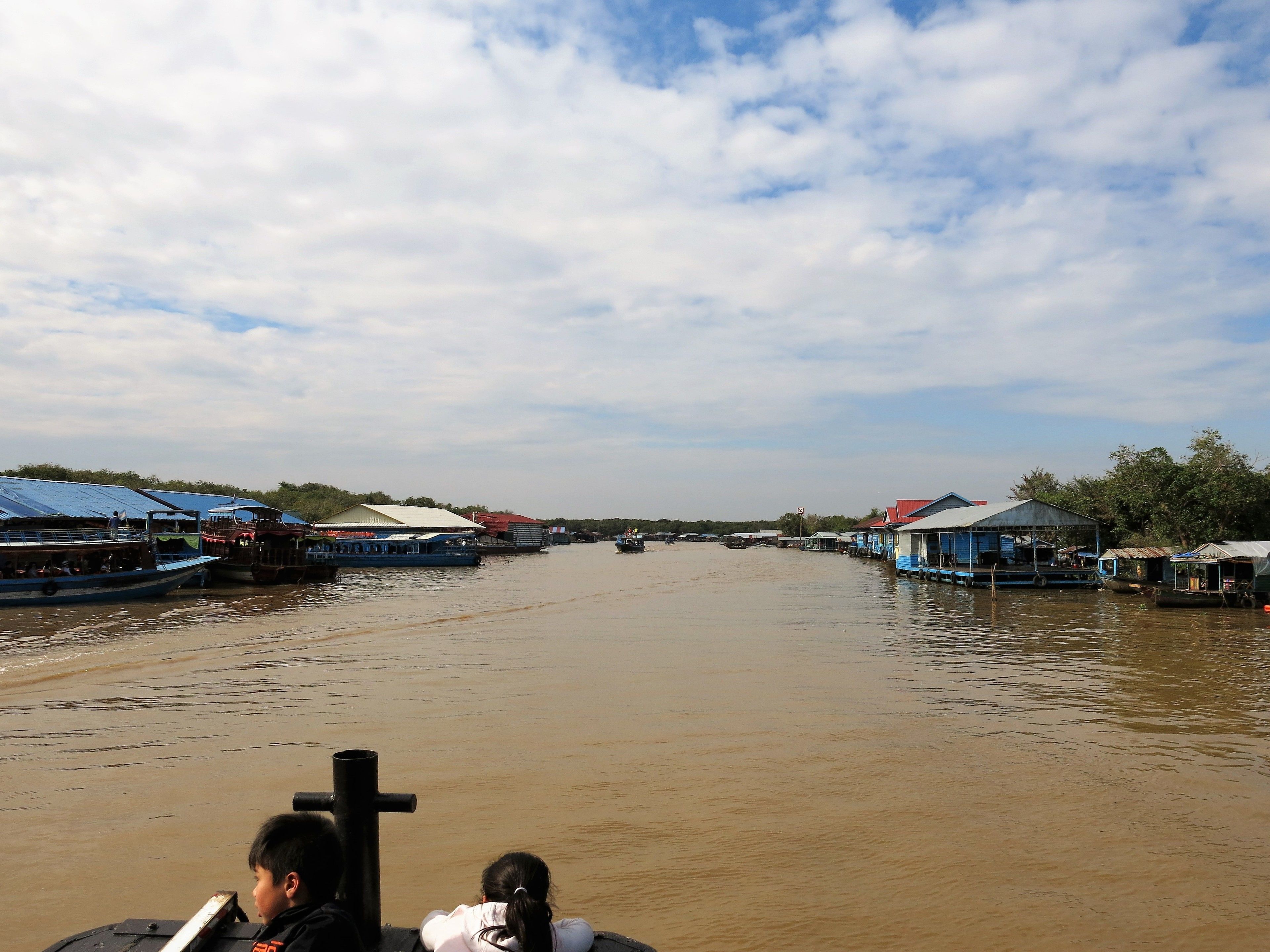 A river with boats and houses on the banks.