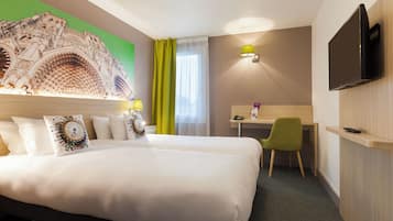Ein Hotelzimmer mit einem großen Bett, einem Schreibtisch, einem Sessel, einem Fernseher und einer Wanddekoration.