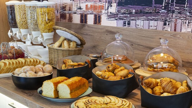 Un bufé con diversos productos horneados y pastelería.