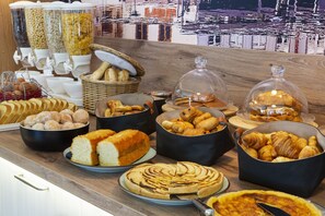 A buffet with various baked goods and pastries. - Brit Hotel Confort Amiens (Longueau)