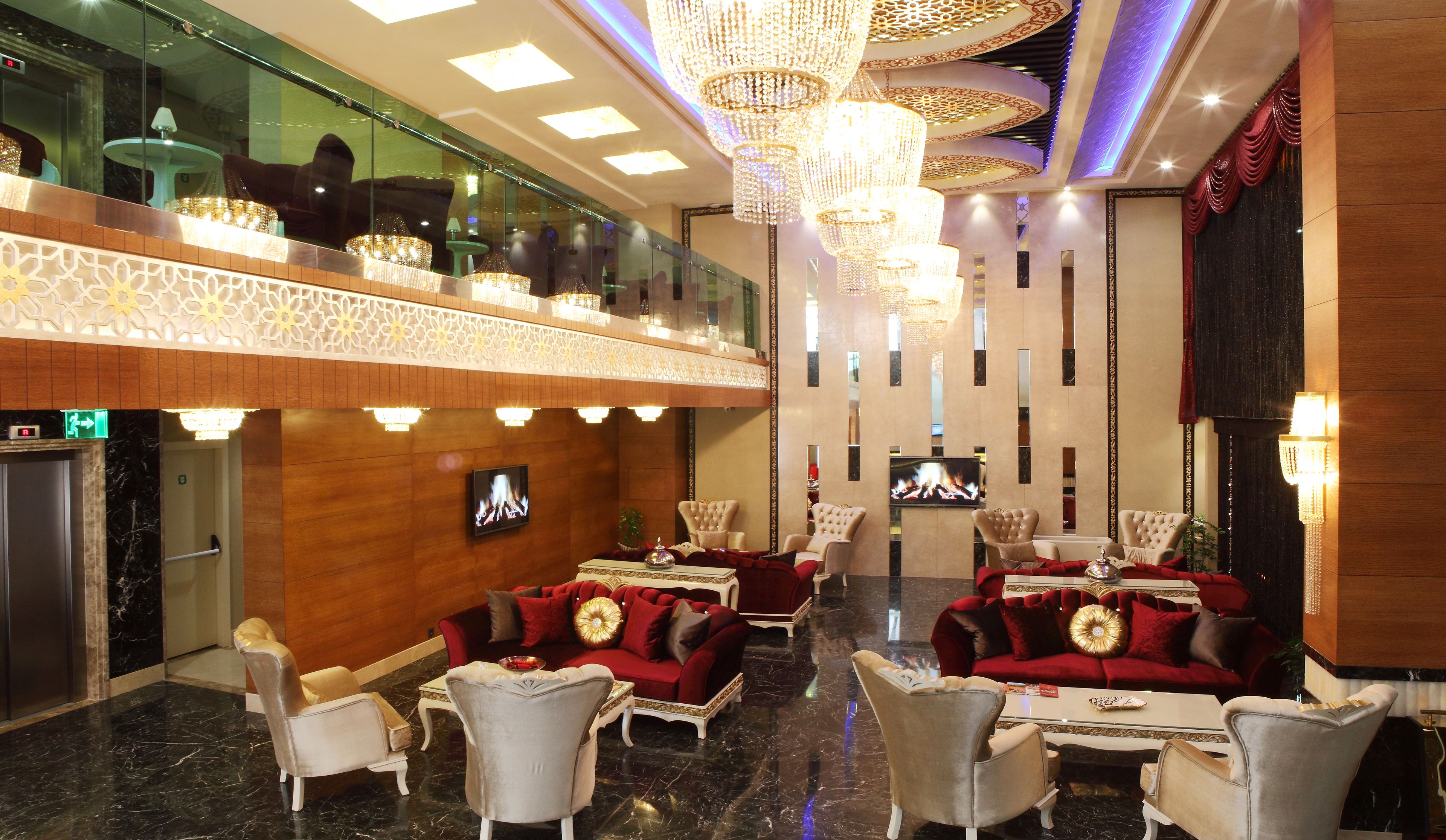 A spacious lobby with high ceilings, ornate chandeliers, and plush seating areas.