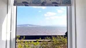 Enjoy the serene ocean view from this room, featuring a tranquil sea and distant landmass.