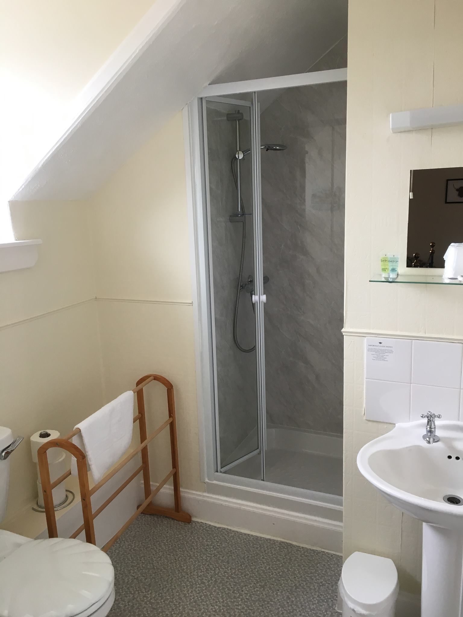 Une salle de bain avec une douche à parois de verre, un lavabo et des toilettes.